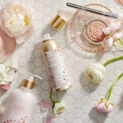 Thymes Goldleaf Gardenia Home Fragrance Mist on bathroom counter with flowers